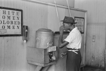 African-American drinking at a ”Colored” water cooler in streetcar terminal, Oklahoma City, Oklahoma in July 1939. Russell Lee