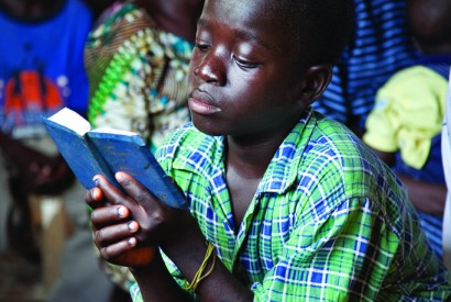 A boy reads his Bible at an Assemblies of God service in Saclepea, Liberia. Laura Elizabeth Pohl/Bread for the World.