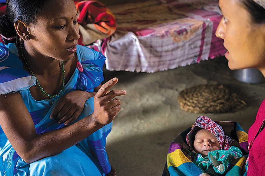 A community health worker in Nepal performs a routine check-up on mother and baby to make sure both are healthy. Photo: USAID