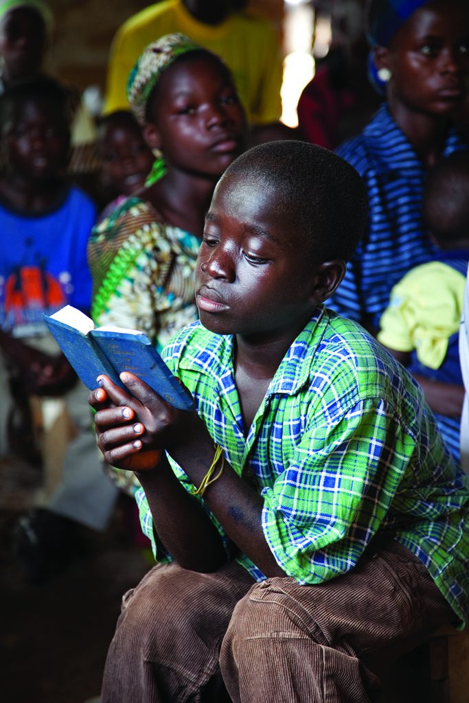 A boy reads his Bible at an Assemblies of God service in Saclepea, Liberia. Laura Elizabeth Pohl/Bread for the World.