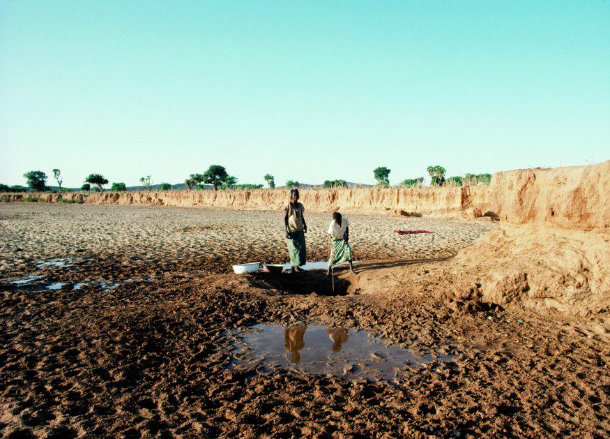 Women in Niger wash clothes with water obtained from a well in the dry riverbed. UN Photo/Jeffrey Foxx.