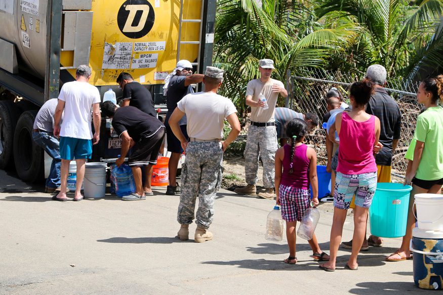 Residents in Toa Baja, Puerto Rico waiting in line to get water brought by the Puerto Rico National Guard. Alexis Velez/Wikimedia Commons.