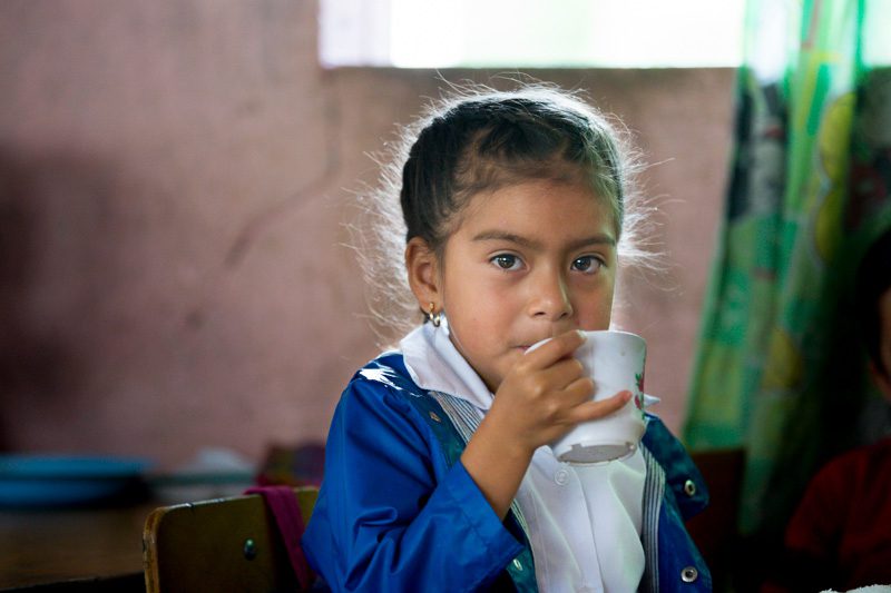 Angie Galvez sips her drink after enjoying her meal provided in rural Guatemala. USAID provides funding for school meals (Food for Education) in some of the most impoverished and malnurished areas. Photo: Joe Molieri / Bread for the World