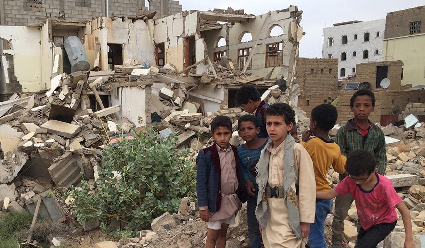 Young boys standing in front of damaged buildings in Saada, Yemen, where bombing has left many neighborhoods in the city are strewn with wreckage and debris following ground fighting between armed groups. Photo: WFP / Jonathan Dumont