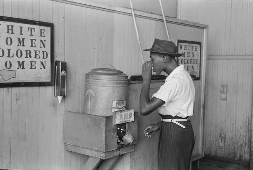 African-American drinking at a ”Colored” water cooler in streetcar terminal, Oklahoma City, Oklahoma in July 1939. Russell Lee